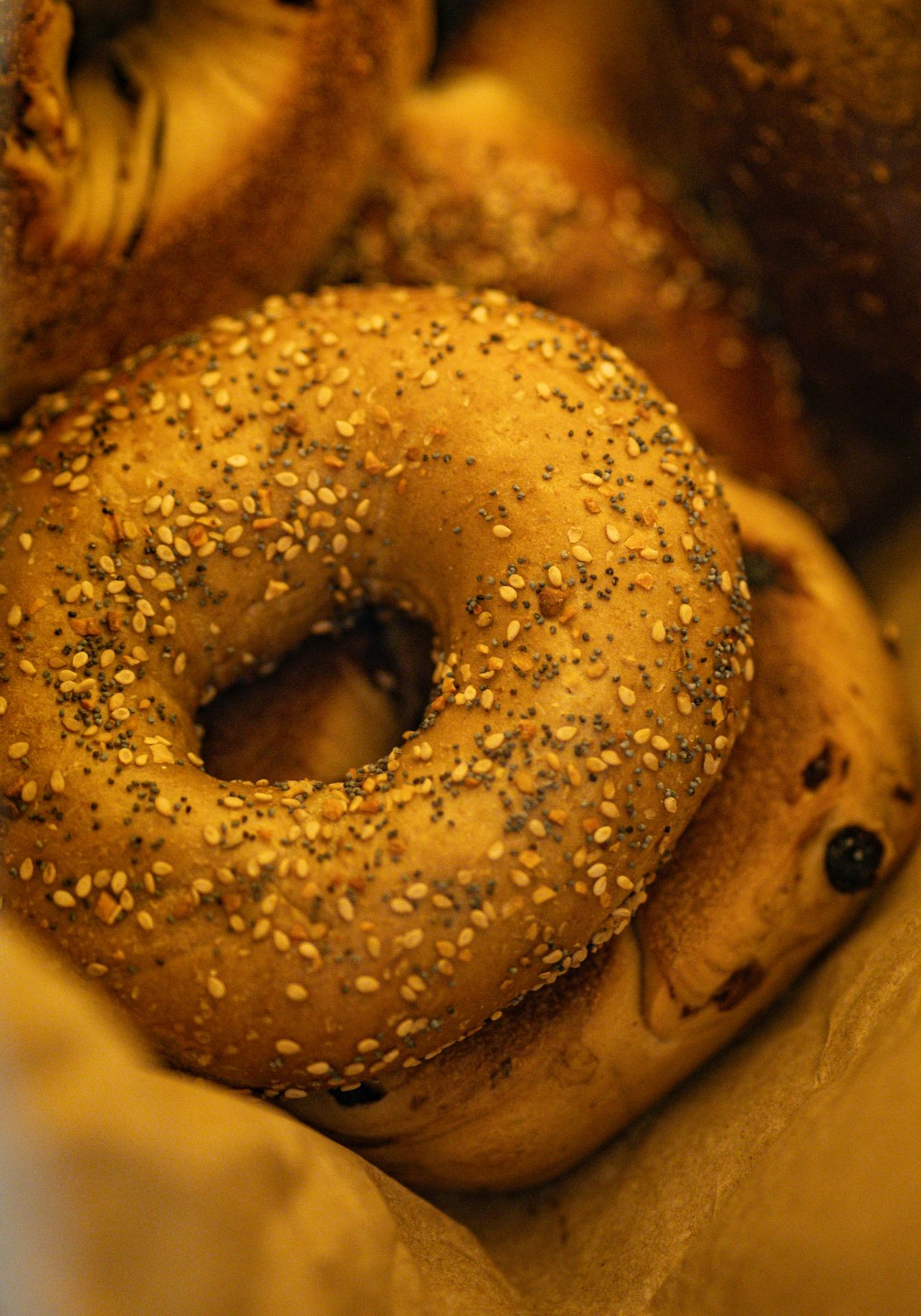 Fresh bagels are piled in a basket.